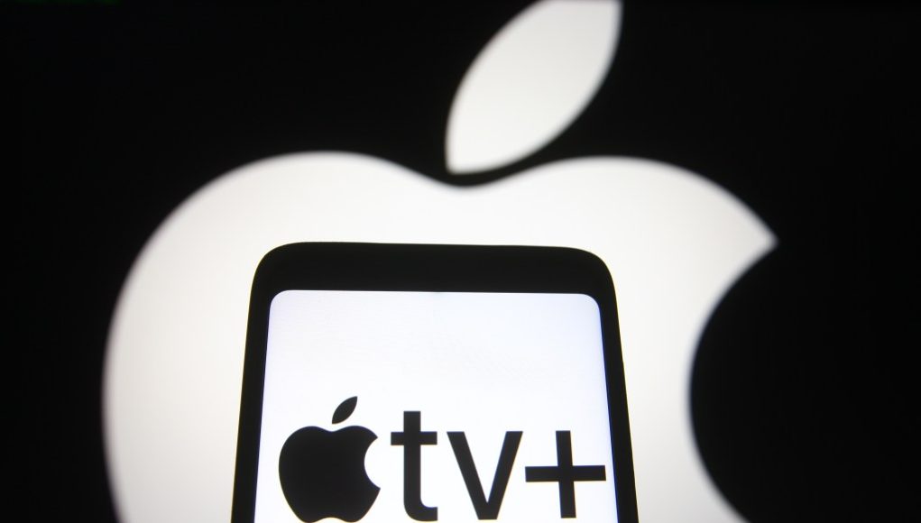 In this photo illustration an Apple TV+ logo is seen on a smartphone screen with an Apple logo in the background.